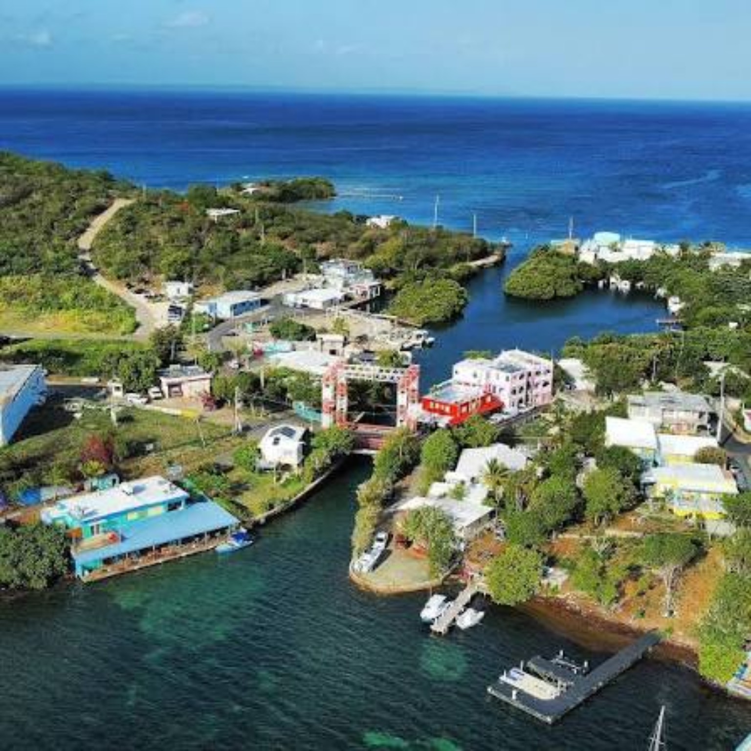 Elevated view over the canal, waterfront buildings, drawbridge area, and bay of Playa Sardina II, Culebra