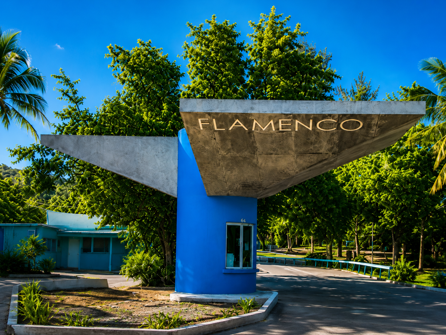 The Flamenco entrance sign and gateway surrounded by trees in Culebra
